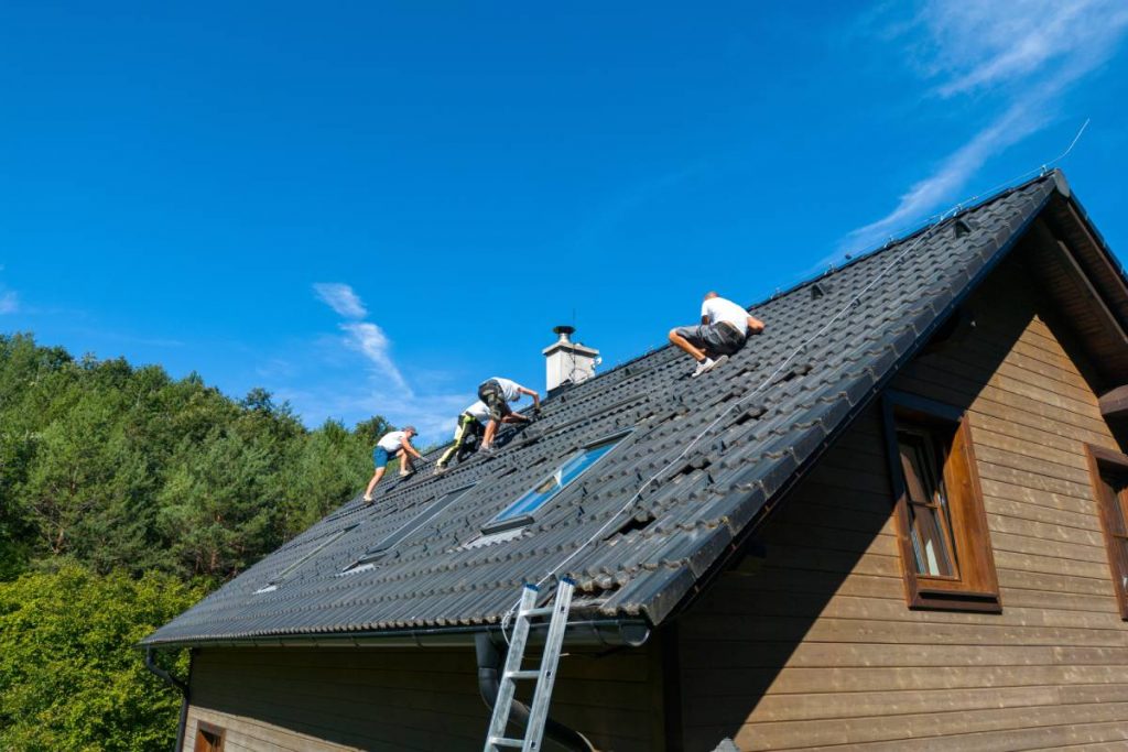Men worker installing solar photovoltaic panels on a roof, alternative energy, saving resources and sustainable lifestyle concept.